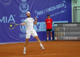 Tennisspieler vor einer Tennisblende