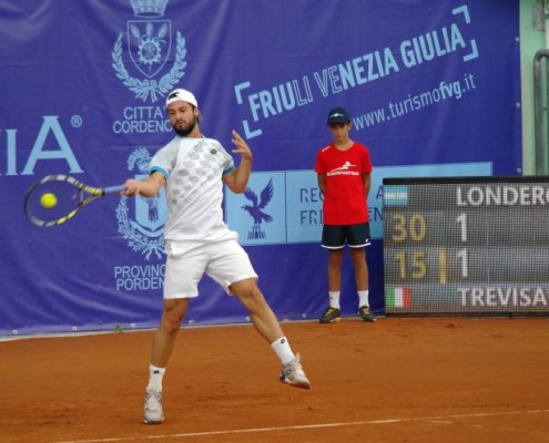 Tennisspieler vor einer Tennisblende